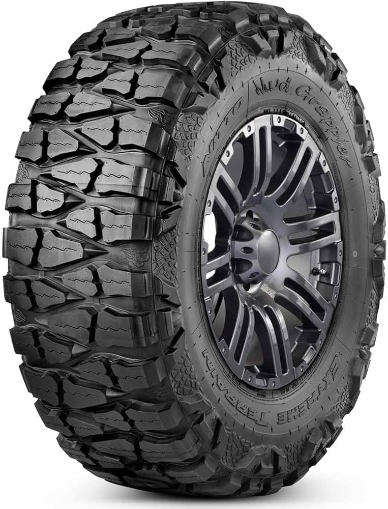 Nitto Mud Grappler extreme terrain tire on a gunmetal alloy wheel, deep tread blocks wrapping onto the sidewall